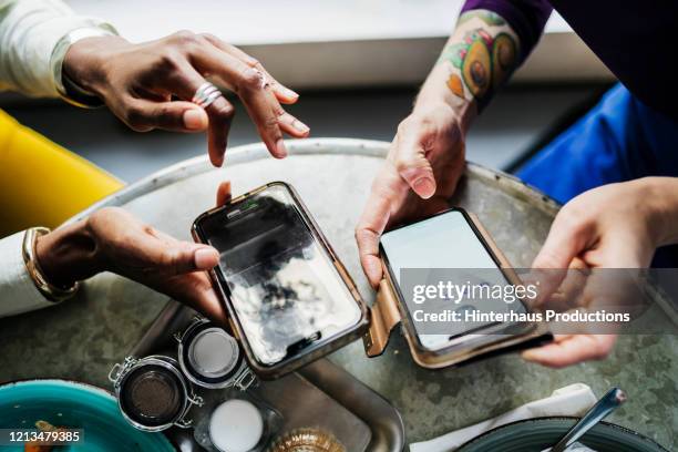 two colleagues swapping contact information in cafe - mobile screen stock-fotos und bilder