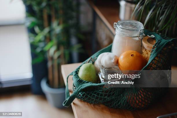 eco bag on kitchen counter with food in jars and fresh fruits. zero waste concept - grocery bag stock pictures, royalty-free photos & images