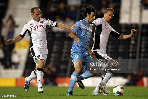 Nikola Kalinic of FC Dnipro is closed down by Danny Murphy and Brede Hangeland of Fulham during the UEFA Europa League Play-Off round qualifying...