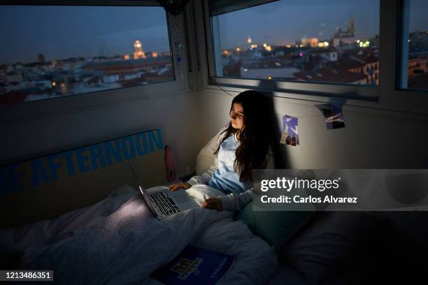 In this photo illustration, a teenage girl watches a series on the bed in her room on March 18, 2020 in Madrid, Spain. As part of the measures...
