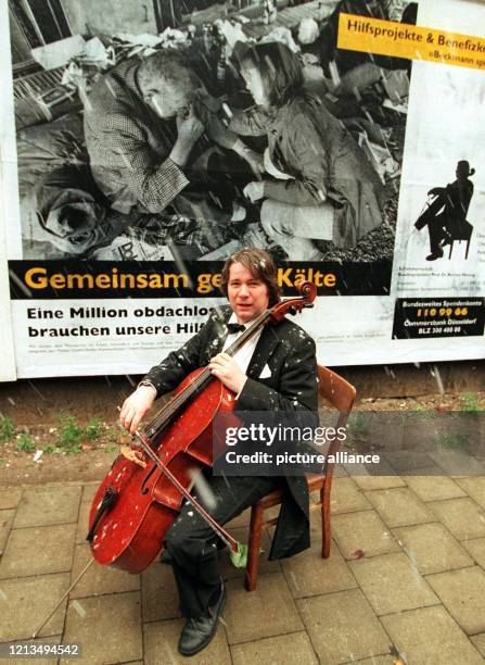 Im Schneetreiben spielt der Düsseldorfer Thomas Beckmann am vor einem Plakat "Gemeinsam gegen Kälte" auf seinem Cello. Mit 50000 Großplakaten des...