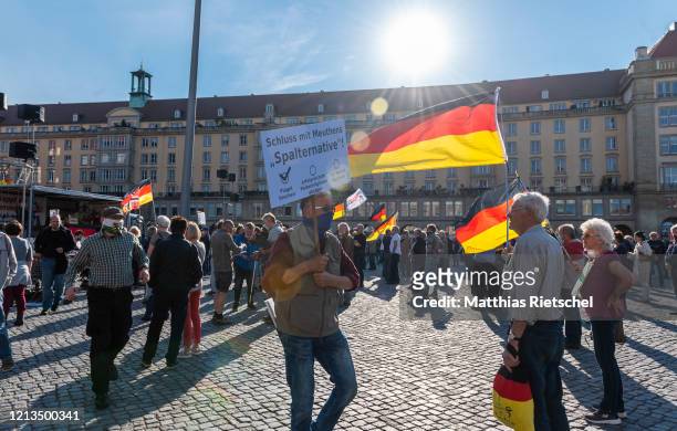 Demonstrator holds a German flag as supporters of the anti-Islam and anti-immigration movement Pegida gather for the resumption of their Monday...