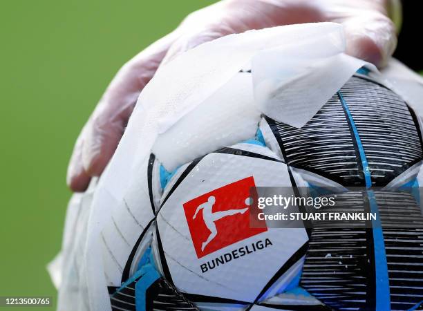 An employee of Werder Bremen disinfects an official match ball ahead of the German first division Bundesliga football match Werder Bremen v Bayer 04...