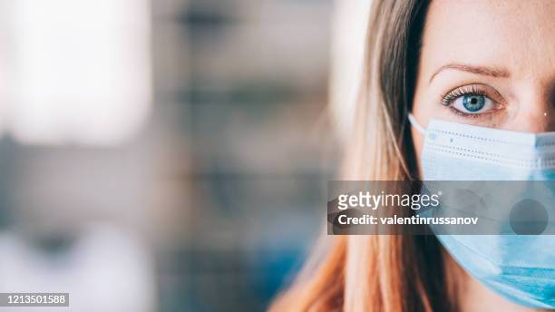 woman wearing protective face mask in the office for safety and protection during covid-19 - covid 19 stock pictures, royalty-free photos & images