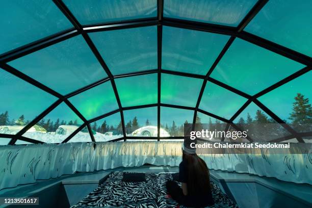 aurora borealis shining in the night sky seen from glass igloos - finland ストックフォトと画像