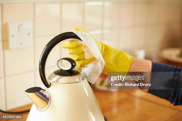 mature woman wiping down her kettle - kettle stock pictures, royalty-free photos & images