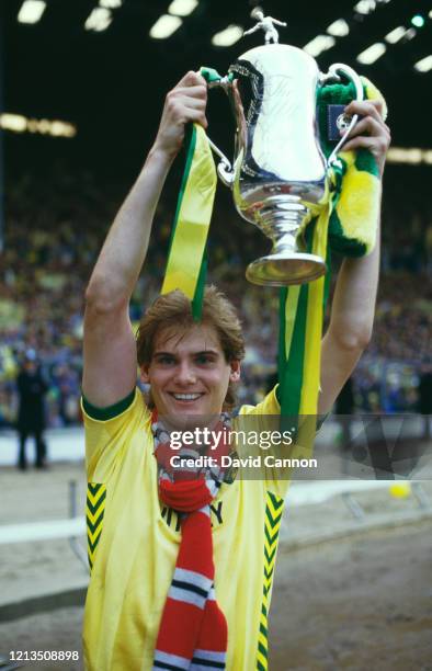 Dennis van Wijk of Norwich City holds the trophy aloft after their 1-0 win over Sunderland in the 1985 Milk Cup Final at Wembley Stadium on March 24,...