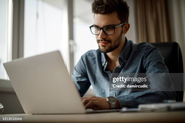 jonge zakenman die aan laptop werkt - laptop work search stockfoto's en -beelden