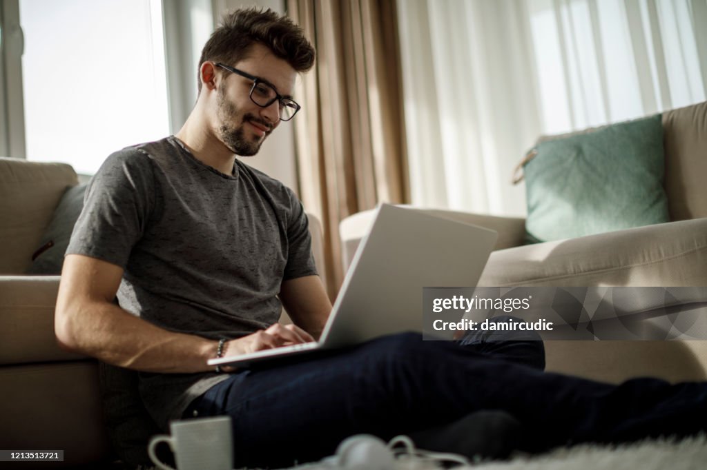 Young man studying and working on laptop at home