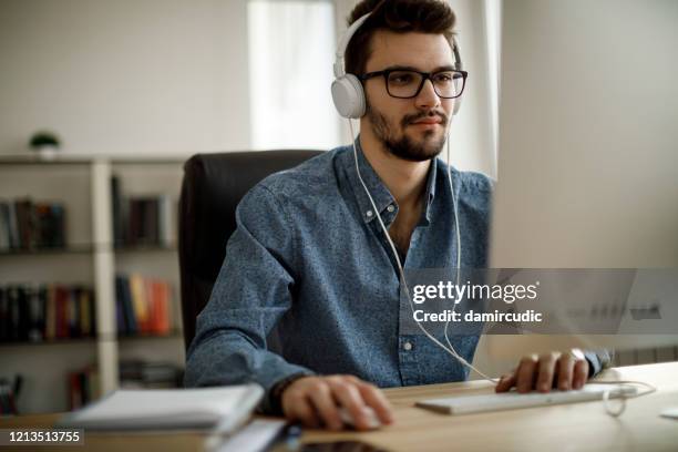 joven que trabaja - auriculares equipo de música fotografías e imágenes de stock