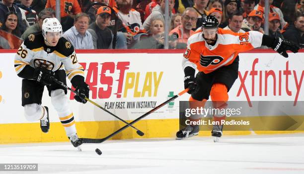 Par Lindholm of the Boston Bruins skates the puck against Kevin Hayes of the Philadelphia Flyers on March 10, 2020 at the Wells Fargo Center in...