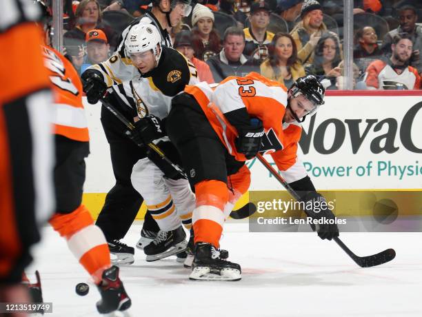 Kevin Hayes of the Philadelphia Flyers battles for the puck on a face-off against Par Lindholm of the Boston Bruins on March 10, 2020 at the Wells...