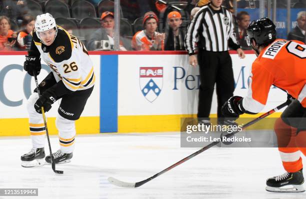 Par Lindholm of the Boston Bruins skates the puck against Ivan Provorov of the Philadelphia Flyers on March 10, 2020 at the Wells Fargo Center in...