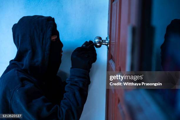 masked thief using lock picker to open locked door - burglary stock pictures, royalty-free photos & images