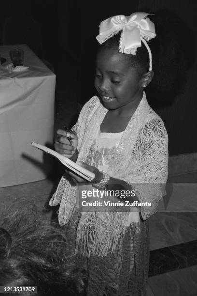 American actress Keshia Knight Pulliam signs autographs for fans, circa 1985.