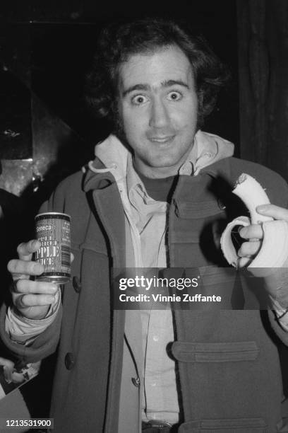 American actor and entertainer Andy Kaufman , eating a banana and drinking a can of Seneca apple juice, circa 1980.