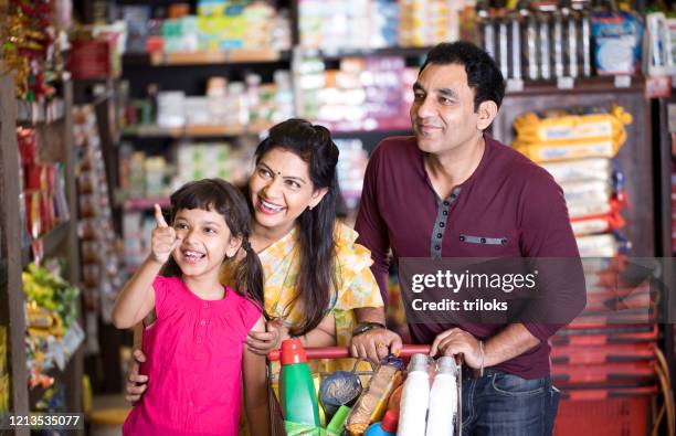 happy family shopping for groceries at the supermarket - indian girl pointing stock pictures, royalty-free photos & images
