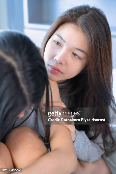 young teen asian couple having arguments and problems in bed. asian beauty sad girl was comforted by a girl friend. people and social issues problem concept. lifestyle and friendships theme. lesbian and family theme. - teen lesbian stockfoto's en -beelden