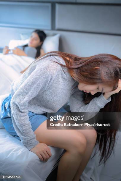 young teen asian couple having arguments and problems in bed. asian beauty sad girl was comforted by a girl friend. people and social issues problem concept. lifestyle and friendships theme. lesbian and family theme. - teen lesbian stockfoto's en -beelden