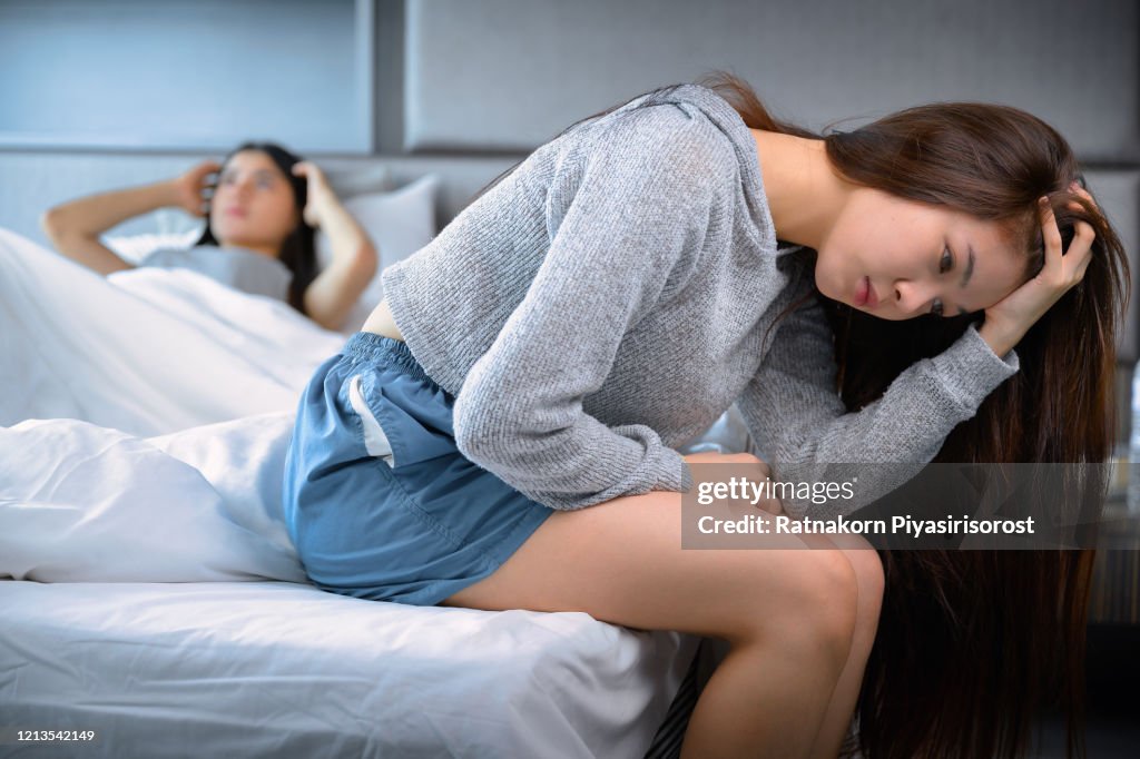 Young Teen Asian Couple having arguments and problems in bed. Asian beauty sad girl was comforted by a girl friend. People and social issues problem concept. Lifestyle and Friendships theme. Lesbian and family theme.