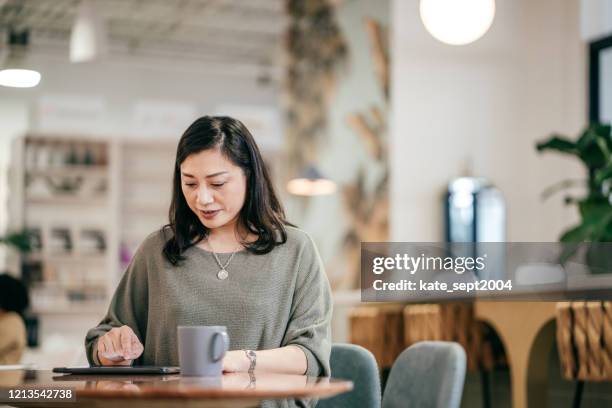 productief zijn tijdens het werken vanuit huis - woman filling out paperwork stockfoto's en -beelden