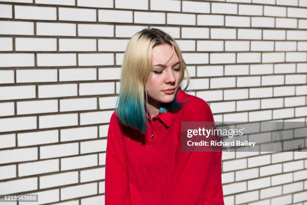 quirky teenage girl against a brick wall - girl with blue hair stock pictures, royalty-free photos & images