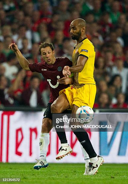 Hanover's US defender Steven Cherundolo vies with Sevilla FC's Malian striker Frédéric Kanouté vie for the ball during the UEFA Europa League play...