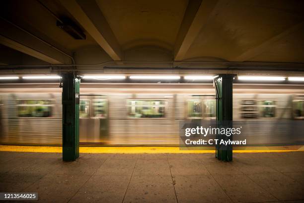 train arriving at new york subway station - new york city subway stock-fotos und bilder