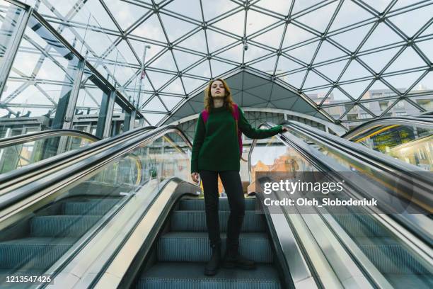 woman on escalator to underground in copenhagen - copenhagen metro stock pictures, royalty-free photos & images