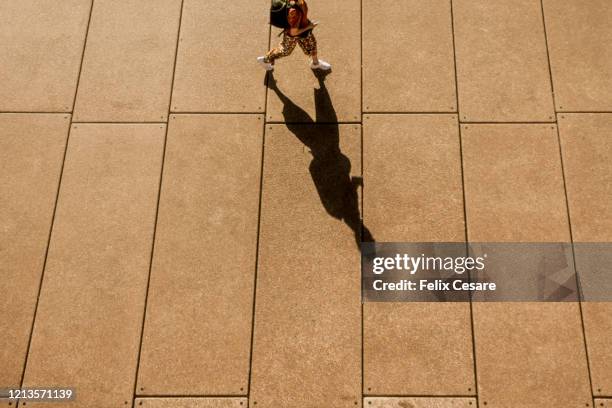 a long shadow of a person walking - sombra larga sombra fotografías e imágenes de stock