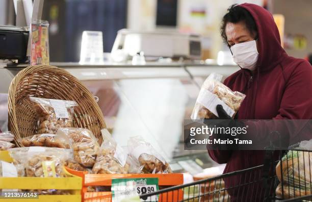 Senior wears a face mask while shopping for groceries during special hours open to seniors and the disabled only at Northgate Gonzalez Market, a...