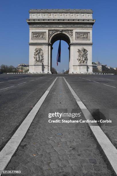 General view of the Arc de Triomphe, at the end of the empty "Avenue des Champs Elysees" on the third day after the announcement by French President...