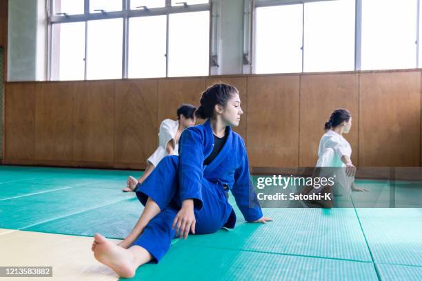 three judo athletes stretching in dojo - judo stock pictures, royalty-free photos & images