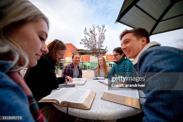 a group of students having a discussion and studying the bible - church group stock pictures, royalty-free photos & images