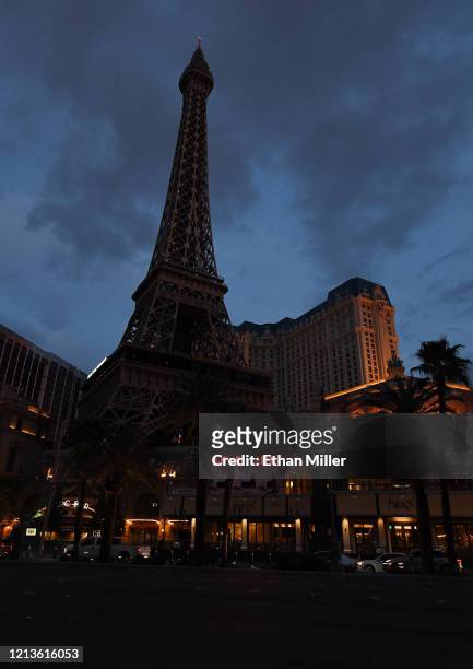Most of the exterior building lights at Paris Las Vegas, including on its 50-story replica Eiffel Tower, are turned off as parts of the Las Vegas...