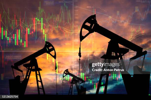 oil pump with candle stick graph chart in the background. world oil industry - gas pump fotografías e imágenes de stock