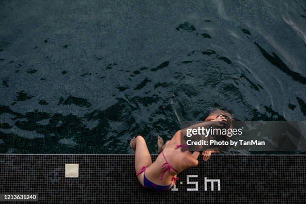 a woman checks on a boy at the edge of a swimming pool in maldives. - ocean pool stock pictures, royalty-free photos & images