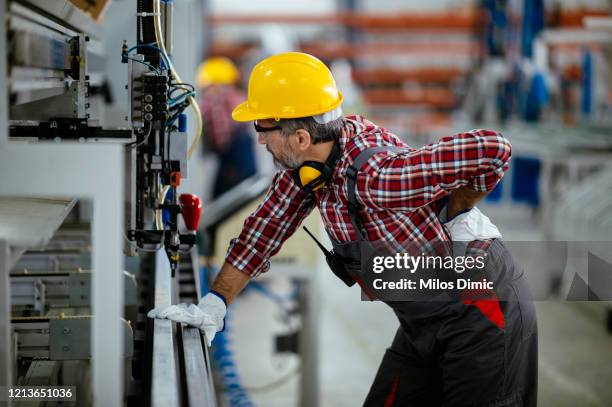 trabajador de la fábrica con dolorosa lesión en la espalda foto de stock - physical injury fotografías e imágenes de stock