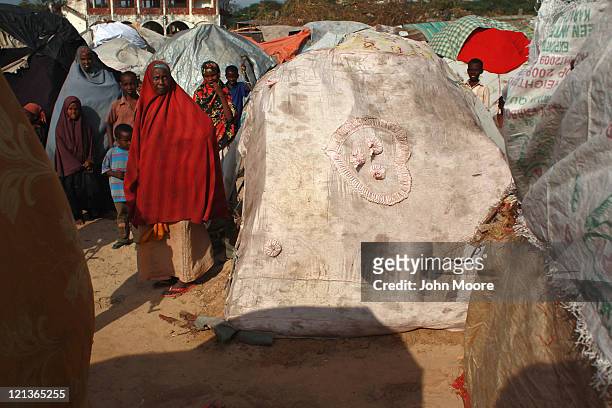 Family's bedcover stretches over their newly-constructed hut in a camp for Somalis displaced by drought and famine on August 18, 2011 in Mogadishu,...