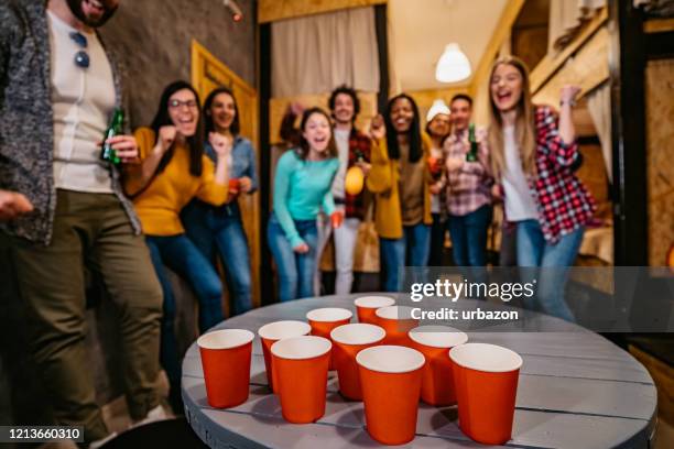 jonge mensen die bierpong in herberg spelen - beirut stockfoto's en -beelden