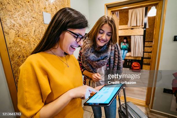 hostel worker showing room to female tourist - hostel stock pictures, royalty-free photos & images