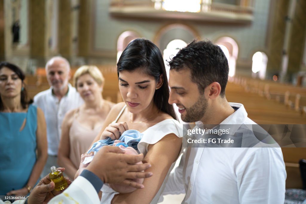 Padrinos con un bebé ahijado en la celebración del bautismo