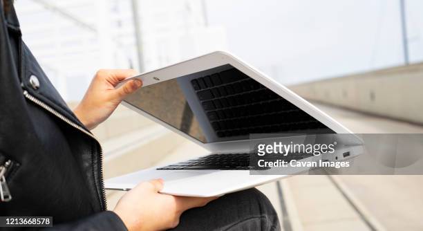 woman closing her white laptop. - laptop netbook stock pictures, royalty-free photos & images
