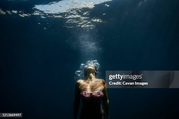 adult woman relaxed under the mediterranean sea in menorca, spain. - subacuático fotografías e imágenes de stock