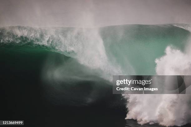 massive wave spiting a huge barrel under the cliffs of moher, ireland - ireland surf wave ストックフォトと画像