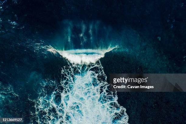 aerial view of a perfect wave breaking over a lava reef in tenerife - surf tube stock-fotos und bilder