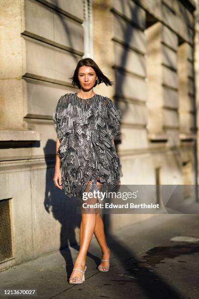 Landiana Cerciu wears a black and white Rahul Mishra dress with a feather-design and geometric patterns, during Paris Fashion Week - Womenswear...