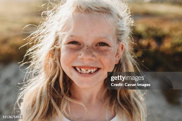 close up portrait of young school age girl with freckles smiling - blonde girl freckles - fotografias e filmes do acervo