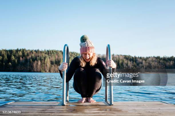 woman looking nervous about cold water ice swimming in sweden - do it stock pictures, royalty-free photos & images