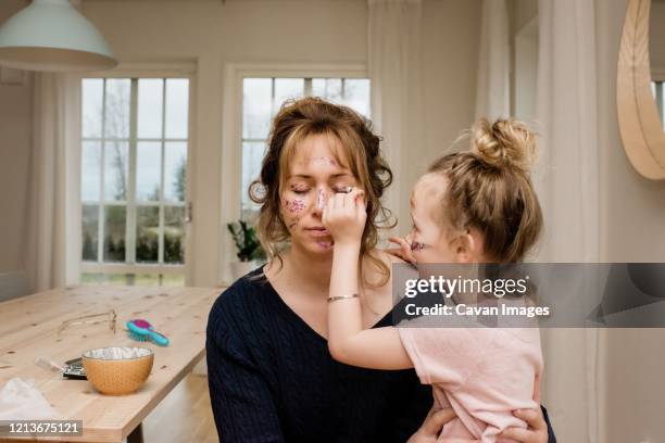 mother and daughter playing dress up with make up & glitter together - sparkle children stock pictures, royalty-free photos & images